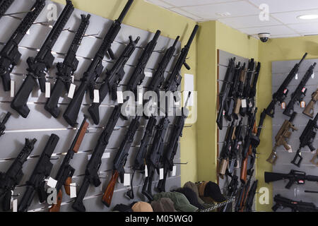 Varietà di pistola pneumatica è appeso alla parete in negozio militare Foto Stock