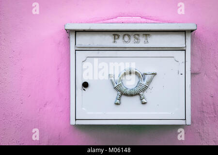 Un bianco di bloccaggio cassetta postale si siede su una parete rosa in Germania. Foto Stock