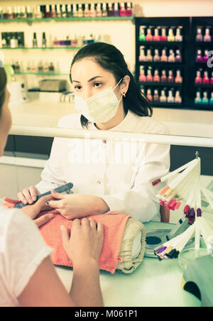 Processo professionale di manicure da lima per unghie nel moderno salone di bellezza Foto Stock