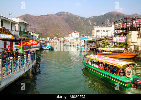 HONG KONG - Apr 11, 2011: un tour boat che trasportano i visitatori crociere lungo Tai o fiume dove le tradizionali case costruite su palafitte sopra la marea Foto Stock