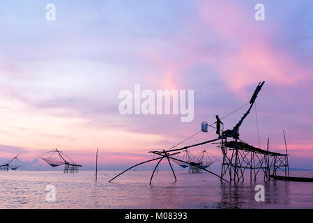 I pescatori intingere la sua rete di sollevamento in acqua per la cattura di gamberetti all'alba ,Phatthalung Thailandia Foto Stock
