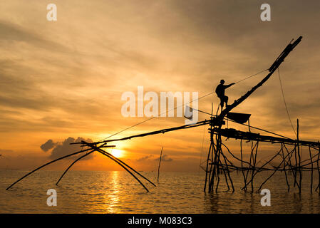 I pescatori intingere la sua rete di sollevamento in acqua per la cattura di gamberetti all'alba ,Phatthalung Thailandia Foto Stock