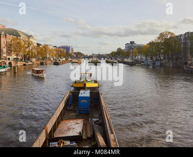 Tirare tirare un chiatta industriale sul fiume Amstel andando verso Amstelsluizen paratoie (risalente al 1674), Amsterdam, Paesi Bassi Foto Stock