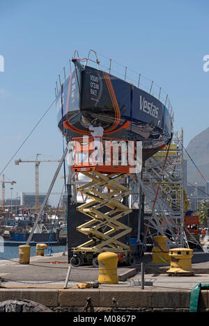 Cape Town Waterfront Sud Africa. Dicembre 2017. Volvo Ocean Race. Racing yacht Vestas. La lucidatura dello scafo da operaio su un elevatore a pantografo pre gara. Foto Stock