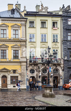 Lviv, Ucraina - 31 Maggio 2016: pedoni con un ombrelloni sulle stradine della vecchia città europea sotto la pioggia di primavera di Lviv, Ucraina. Foto Stock