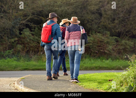 Tre persone di mezza età o persone anziane che due uomini e una donna che indossa ampia colmato cappelli fuori passeggiate o escursioni lungo itinerari nell'isola di Wight in estate Foto Stock