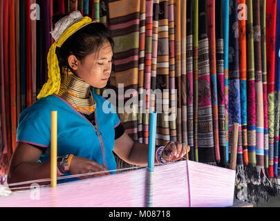 Lungo collo donna tribale tessitura di seta nel suo villaggio, Thailandia Foto Stock