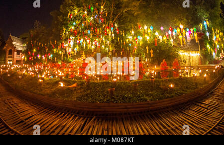 Il debuttante monaci seduti vicino alla statua del Buddha e condurre le preghiere a Yi Peng Festival, Chiang Mai, Thailandia Foto Stock