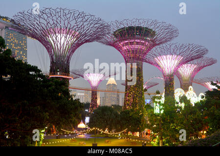 Singapore, Singapore - 11 dicembre 2017. Illuminato Supertrees futuristico a giardini dalla Baia di Singapore, con persone. Foto Stock