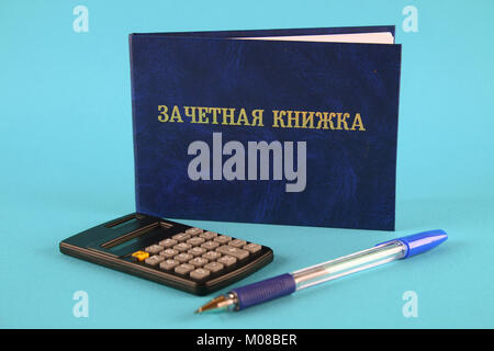 Un libro blu con una scritta in russo - uno studente il record di un libro. Penna, calcolatrice su uno sfondo blu. Gli studenti giorno Foto Stock