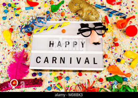 Lightbox con lettere - HAPPY CARNEVALE - sulla colorata festosa decorazione di partito con vaporizzatori, coriandoli e ballons. Foto Stock