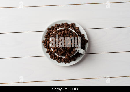 Chicchi di caffè tostati all'interno bianco tazza di caffè Foto Stock