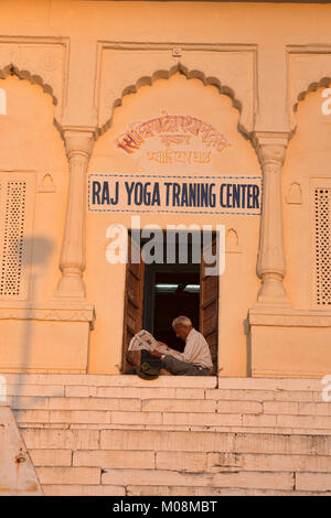 Istruttore Yoga lettura nel sole, Pushkar, Rajasthan, India Foto Stock