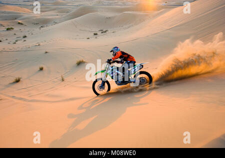 ABU DHABI, Emirati Arabi Uniti - 01 GEN 2018: un uomo su un dirt bike è a cavallo sulle colline nel deserto negli Emirati Arabi Uniti. Foto Stock