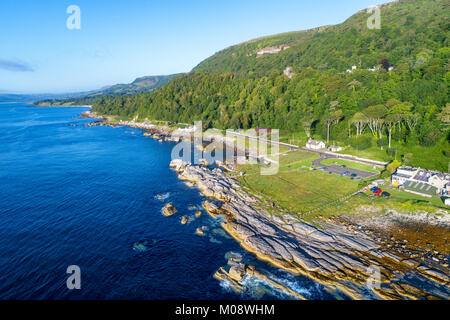 La costa orientale dell'Irlanda del Nord con parcheggio a Goran Point e costiera di Antrim Road, a.k.a. Causeway percorso costiero. Vista aerea di sunrise Foto Stock