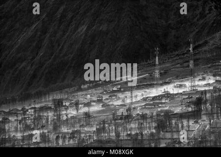 Misty fluente attraverso il villaggio di mattina presto come il sorgere del sole, bromo, Indonesia Foto Stock