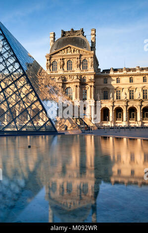 Parigi. La piramide di vetro nel cortile di Napoleone del Louvre si riflette in acqua calma Foto Stock