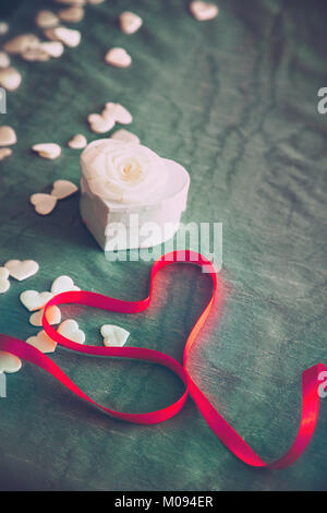 Il giorno di San Valentino la tabella. A forma di cuore scatola con nastro rosso. Regalo per il giorno di San Valentino.San Tabella di San Valentino Foto Stock