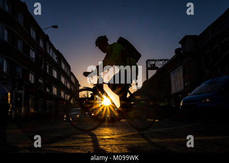 I ciclisti si sposteranno attraverso il London Bridge in una fredda ma limpida giornata invernale nella capitale Foto Stock