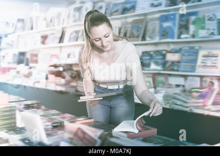 Donna acquistare libri in copertina rigida in bookstore Foto Stock