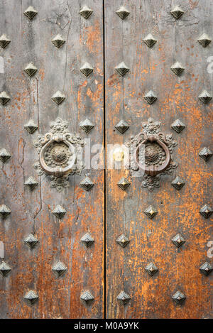 Due antiche porte battenti sulla antica porta a Bologna Italia con vernice peeelng e stagionato in ottone. Foto Stock