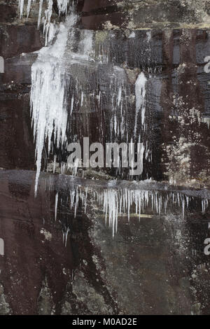 Il freddo giorno d'inverno. Cascata con sfocata del flusso d'acqua, rocce in un ruscello o flusso. Foto Stock