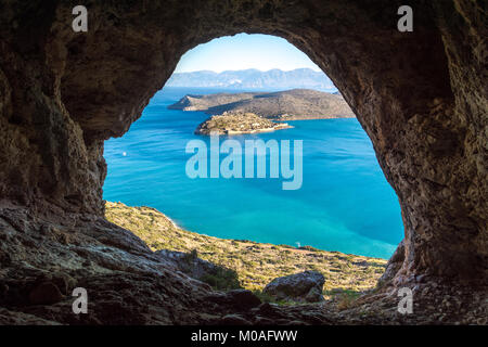 Vista panoramica del golfo di Elounda con isola di Spinalonga. Vista dalla montagna attraverso una grotta, Creta, Grecia. Foto Stock