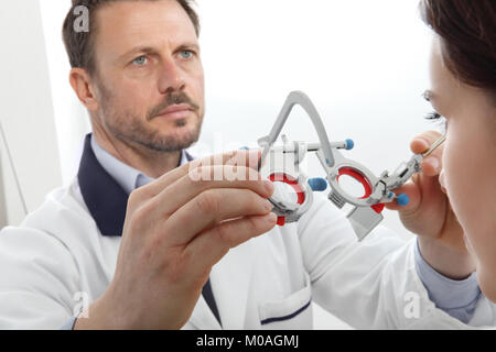 Ottico mani con telaio di prova, all'ottico optometrista medico esamina la vista frontale schematica isolato su bianco Foto Stock