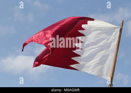 La bandiera nazionale del Qatar, volando da un pennone di Doha. Foto Stock