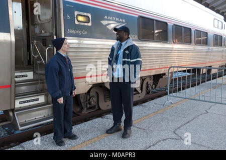 Due maschio Amtrak porter dipendenti aventi una conversazione mentre in corrispondenza di una stazione break in Florida. Foto Stock