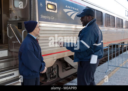 Due maschio Amtrak porter dipendenti aventi una conversazione mentre in corrispondenza di una stazione break in Florida. Foto Stock
