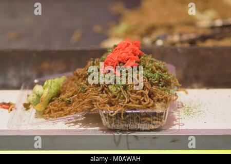 Famoso Japanese street food chiamato Yakisoba essendo disposti in corrispondenza di banchi di cibo a Tokyo Foto Stock