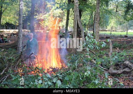 Blazing outdoor falò nei boschi del Nord, Styal village ,essendo alimentato dalla National Trust volontari di Manchester Foto Stock