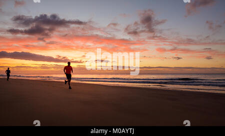 Due guide di scorrimento sono in esecuzione sulla spiaggia di sunrise. Foto Stock