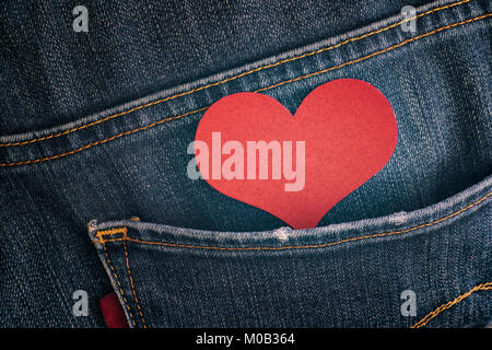 Carta rossa cuore nella tasca dei jeans. Close up. Foto Stock