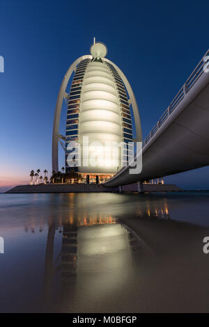 Burj al Arab riflessioni nel surf preso sulla spiaggia al di fuori del Jumeirah al Naseem Hotel a Dubai, Emirati Arabi Uniti Foto Stock