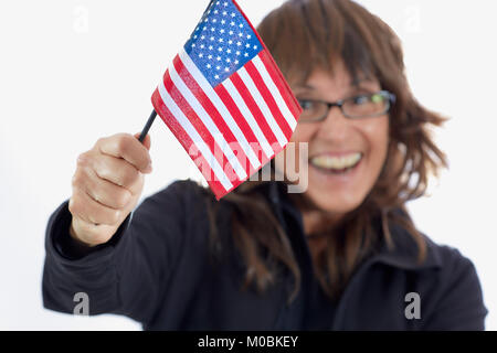 Attraente donna di mezza età con marrone capelli stratificata indossando occhiali e sorridere mentre sventola una bandiera americana isolato su bianco Foto Stock