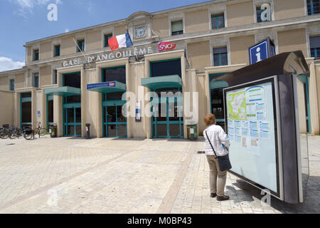 Angouleme, Francia - 26 Giugno 2013: Donna guardando gli orari di fronte alla stazione ferroviaria. L'edificio della stazione è parte dell'ex Collegio Royal de Foto Stock