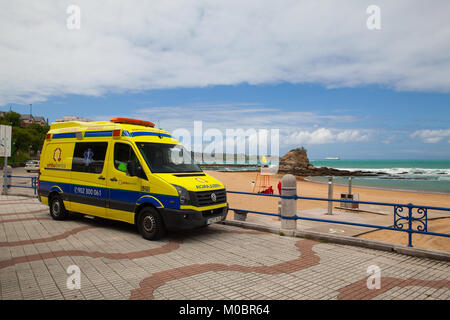 Santander, Spagna - Luglio 1, 2017: un'ambulanza van, parcheggiata nella zona della spiaggia, pronto a reagire in caso di emergenza.Empty El Sardinero beach promenade, S Foto Stock