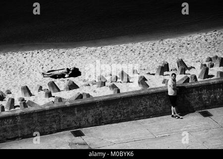 In bianco e nero di Hel Town Waterfront presso il Mar Baltico, spiaggia rafforzati con calcestruzzo blocchi frangiflutti in sabbia, contrastando le linee diagonali Foto Stock