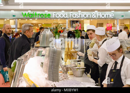 London, Regno Unito - 25 novembre 2017 - Personale di servire i clienti in una barra di cibo in Canary Wharf con Waitrose supermercati in background Foto Stock