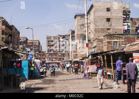 Vista giù per una strada a Huruma, un quartiere di Nairobi, mostrando persone ed edifici, Nairobi, Kenya, Africa orientale Foto Stock