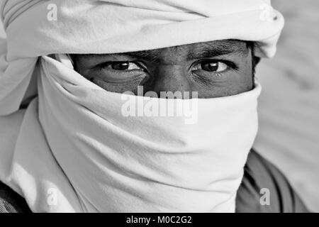 Arabo gli uomini con testa sciarpe nel deserto la luce del sole e sabbia Foto Stock