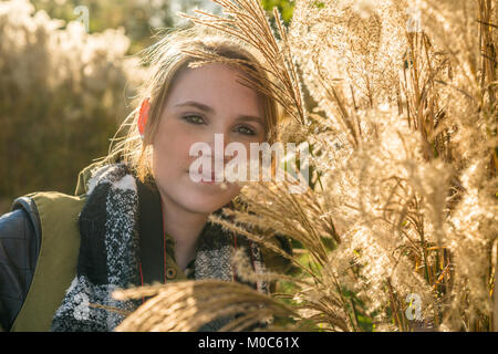Giovane donna guarda nella telecamera e si erge tra le boccole in posizione di parcheggio Foto Stock