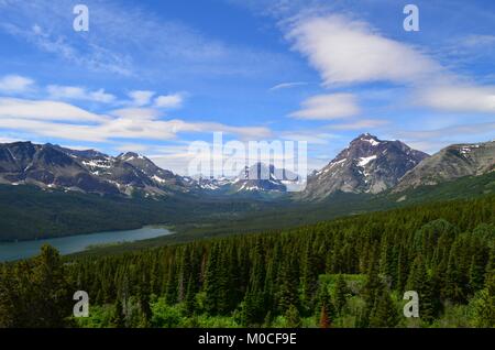 Una splendida panoramica di abbassare St Mary's lake, in estate, con neve sulle montagne in distanza Foto Stock