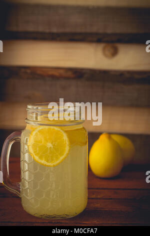 Limonata Fresca a mason jar e limoni su sfondo di legno Foto Stock