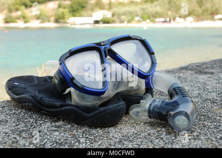 Un boccaglio e maschera e sulla spiaggia di ciottoli a Spartohori sull'isola greca di Meganisi il 31 agosto 2008. Foto Stock