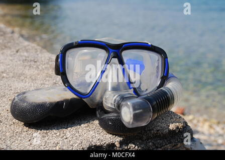 Un boccaglio e maschera e sulla spiaggia di ciottoli a Spartohori sull'isola greca di Meganisi il 31 agosto 2008. Foto Stock