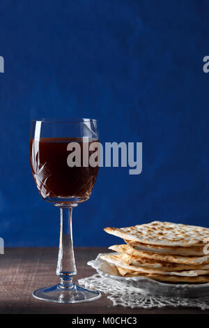 Un Matzah ebraica pane con vino su sfondo blu. Pasqua il concetto di vacanza Foto Stock