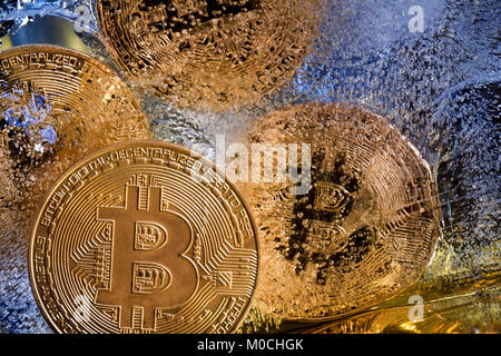 Vista di monete d'oro di Bitcoin cryptocurrency congelate in ghiaccio Foto Stock